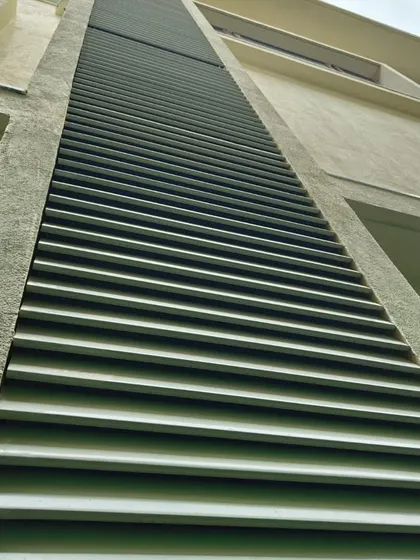 This upward shot emphasizes the length and uniformity of our metal louver installation, creating a sense of height and grandeur. It's a functional solution for sun shading and ventilation.