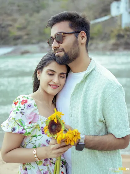 A tender portrait of a couple on the beach, the woman resting her head on her partner's chest, both with serene expressions.