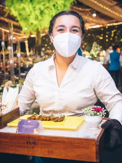 A server presents a tray of appetizers, showcasing our professional service style.