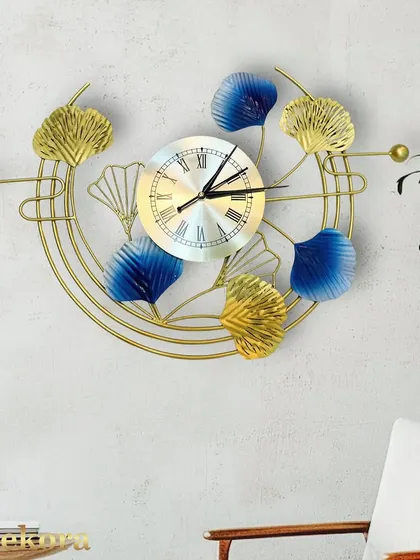 A clear view of the blue and gold ginkgo leaf clock, highlighting the textured details on the metal leaves.