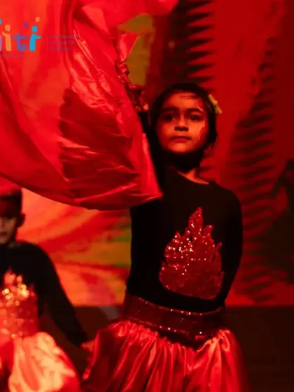 A girl dances with a red cloth, the movement creating the illusion of a dancing flame.