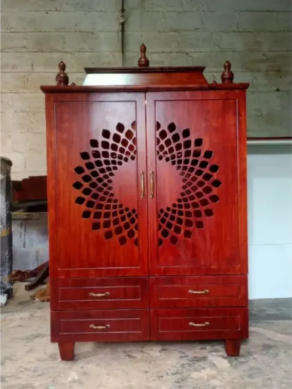 A compact, standalone pooja mandir crafted from rich, dark wood. The doors feature a beautiful laser-cut circular pattern, and the unit includes drawers for storing pooja essentials, making it perfect for smaller spaces.