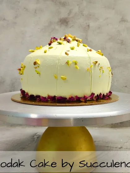 For Ganesh Chaturthi, I offer a modern take on a traditional sweet with my signature Modak Cake. This 100% eggless cake is shaped like a modak and delicately flavored, garnished with premium pistachios and edible rose petals for an elegant finish.