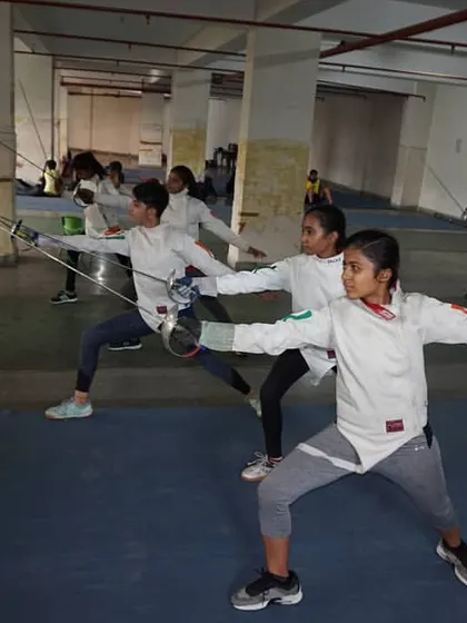 Discipline in motion. A group of our young female fencers execute synchronized lunges during a footwork session, building the muscle memory and precision required for competitive bouting.