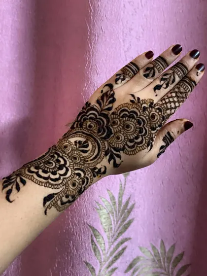 A simple yet stunning Arabic vine design on the back of the hand. This style is perfect for someone who wants an elegant and understated mehendi look.
