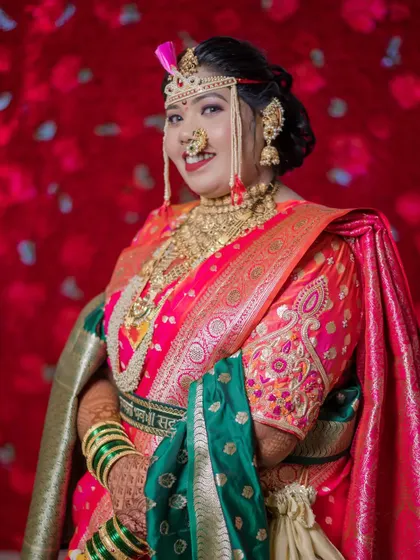 A full-length portrait of the bride against a dramatic red floral background, looking every bit the queen of the day.