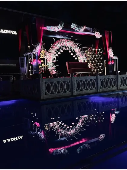 A glamorous reception stage set over a pool, with its reflection creating a beautiful water effect.