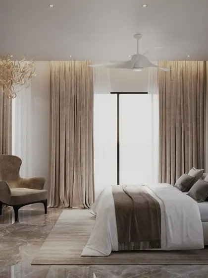 A luxurious bedroom designed to overlook the beautiful Mumbai skyline. The room features elegant curtains, a statement wingback chair, and a stunning modern chandelier that adds a touch of artistry.