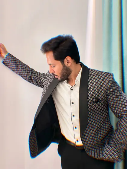 A dynamic, artistic pose against a wall, highlighting the sharp details of the blazer.