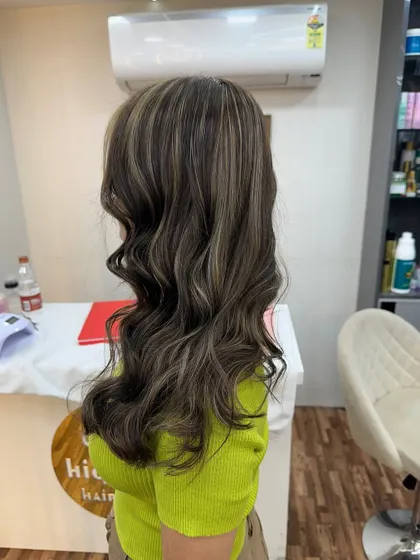 Ash blonde highlights styled into soft waves. This look is perfect for adding a cool, modern touch to your hair.