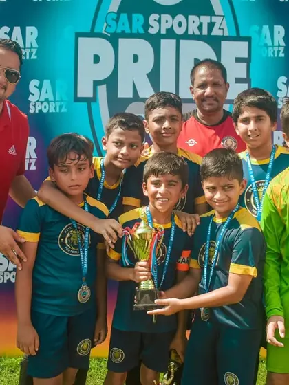 This team proudly shows off their medals and trophy after a hard-fought victory.