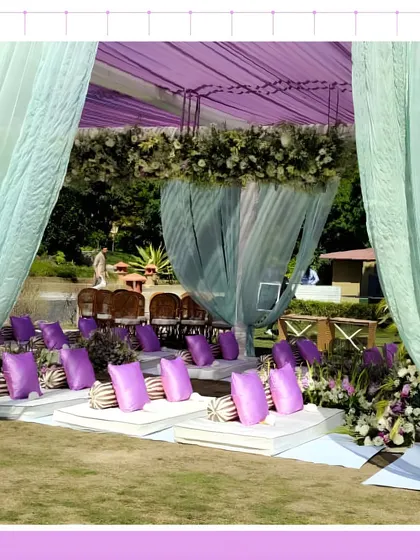 A unique seating arrangement for a ceremony in Jim Corbett, with guests seated on floor cushions under a beautiful canopy.
