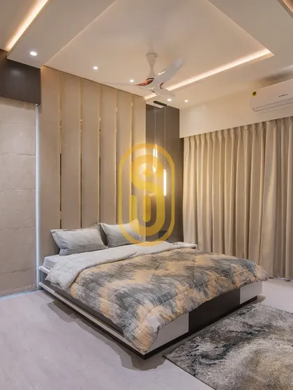 A wider view of the bedroom with the upholstered feature wall, showing the custom bed and matching area rug. The design includes both sheer and blackout curtains for complete light control.