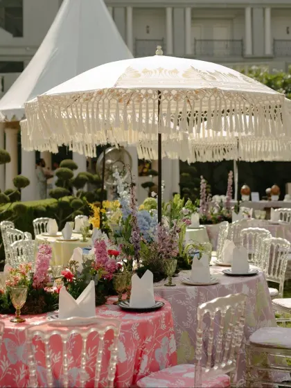 Guest dining tables at the Mehendi, featuring colorful floral-printed linens and elegant fringed umbrellas.