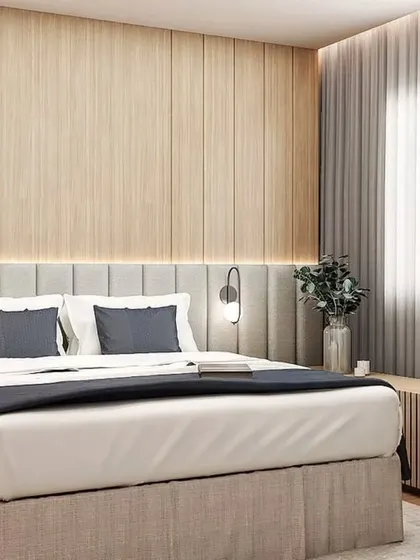A serene bedroom with a wood-panelled accent wall and a comfortable, upholstered bed.