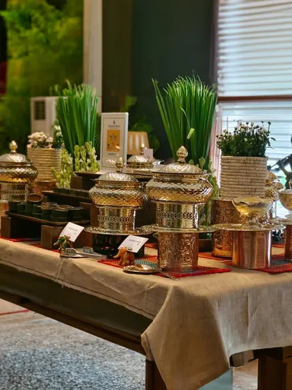 A rustic yet elegant buffet table setup featuring traditional Indian brass and copper serveware, demonstrating our ability to blend traditional aesthetics with modern catering.