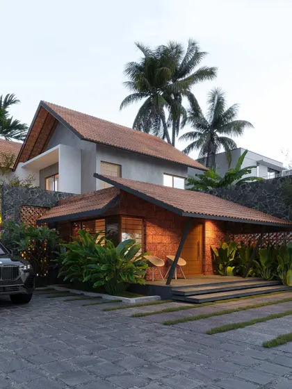 A Palakad residence that uses natural stone and brick under a complex, multi-level tiled roof system for a rustic yet sophisticated look.