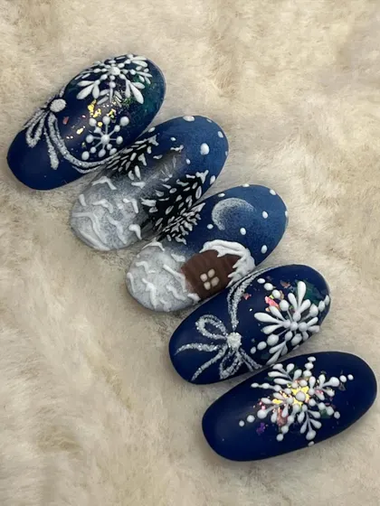 A snowy Christmas scene painted across a set of five nails. This landscape art includes a cozy cabin, snow-covered trees, and sparkling snowflakes.