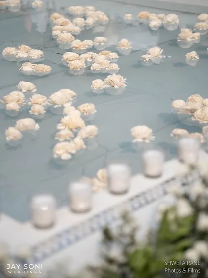 A close-up of the flowers floating in the pale blue water of the pool, a simple yet incredibly effective and beautiful decor detail.