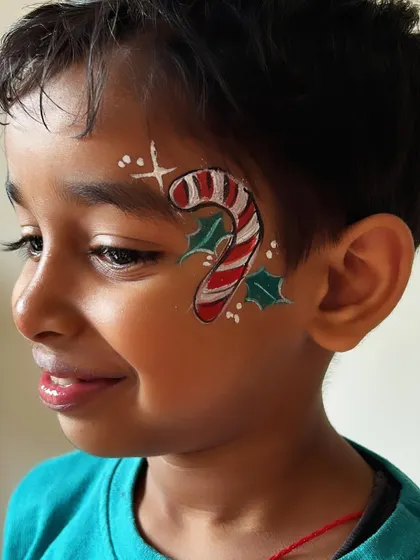 A sweet candy cane with holly leaves. This classic Christmas treat makes for a very popular face paint design.