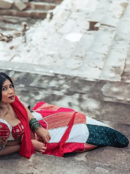 A unique and alluring pose, lying on the stone steps. This shot is artistic and unconventional, blending fashion with a raw, historical setting.
