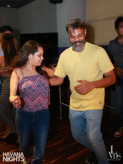Two dancers share a laugh and a smile while grooving on the floor. Our events are casual, friendly, and all about having a good time.