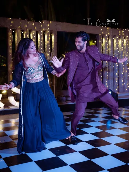 Capturing the pure, unscripted joy of a Sangeet night. A couple dances with abandon on the checkered floor, creating a memory that will last a lifetime.