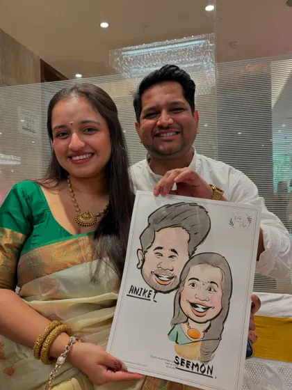 A smiling couple holds up their finished caricature, a fun and artistic keepsake from the wedding festivities.
