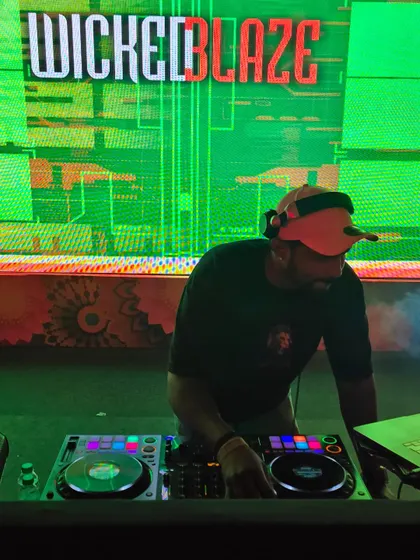 Focused on the mix during a corporate event. The custom "Wicked Blaze" visuals on the LED screen add a personalized touch to the stage production.
