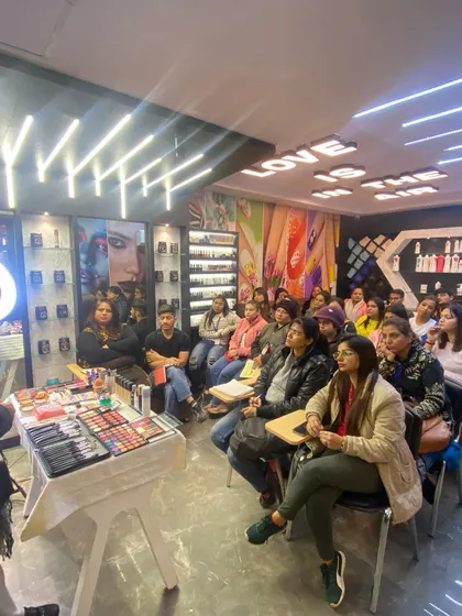 Another view of a makeup workshop in progress. The setup includes a full display of professional makeup kits for students to learn with.