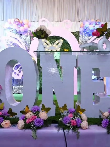 Another angle of the butterfly fairy tale decor, showing the large 'ONE' prop that serves as a cake table.
