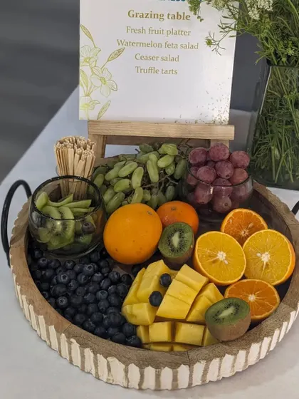 A fresh fruit platter featuring a colorful assortment of kiwi, mango, oranges, and grapes. This was part of a wellness-themed grazing table, emphasizing healthy and delicious options.
