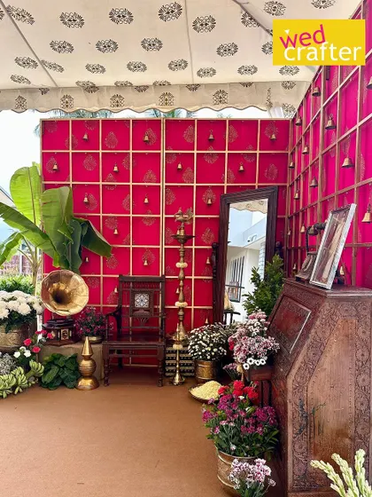 A regal photo corner for a traditional wedding. We used a backdrop of pink fabric with brass bells, vintage furniture like an antique gramophone, and lots of brass artifacts to create this rich, textured look.