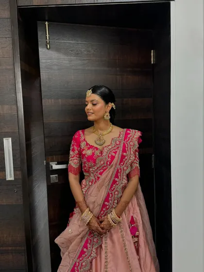 Her look is timeless, with a neat bun, traditional jewelry, and glowing makeup.