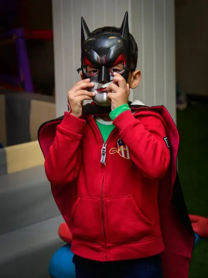 Getting the mask just right. This little Batman is getting into character before heading off to save the day at the party.