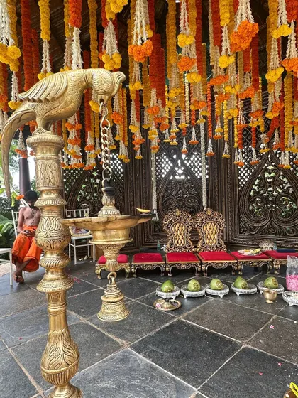 A close-up of the marigold Muhurtham decor, showing the traditional brass lamp and coconuts ready for the ceremony.