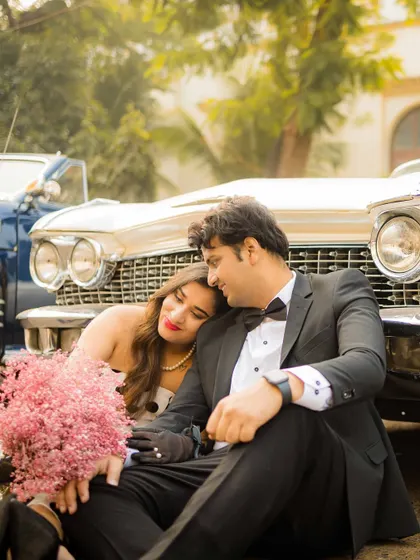 A romantic moment with a vintage Cadillac. The combination of classic formalwear, a beautiful vintage car, and the soft, warm tones creates a dreamy, nostalgic, and incredibly stylish pre-wedding photograph.