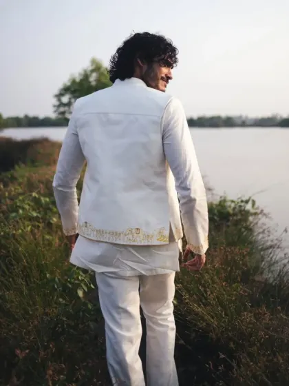 A back view of Vishak Nair's premiere outfit, highlighting the clean tailoring and the subtle, artistic embroidery along the hem of the jacket.
