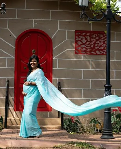 This light blue long trail saree is perfect for a maternity shoot, adding a touch of elegance and flow.