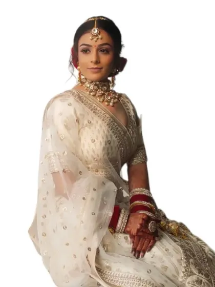 A clean, minimalist shot of the bride in her white lehenga. The makeup is elegant and understated, perfect for a modern wedding.