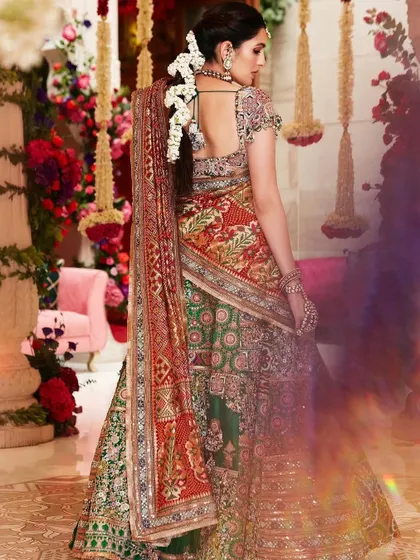The back of this Anamika Khanna lehenga is just as beautiful as the front. The floral hair accessories and the flow of the dupatta complete this regal and traditional look.