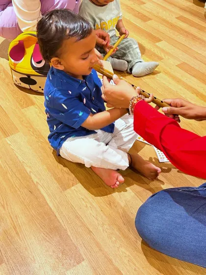 A young student explores the gentle sound of a flute. We encourage children to interact with various instruments to discover different tones and textures.