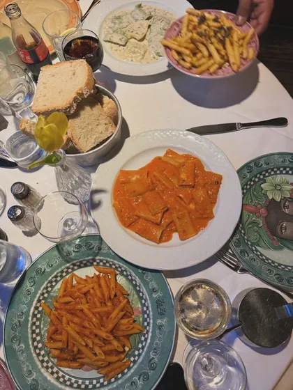 A table filled with our Italian specialties at a catered event. You can see the popular Rigatoni Alla Vodka, truffle fries, and other pasta dishes, showing a feast ready to be enjoyed.