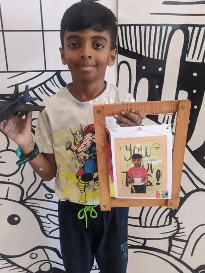 Two projects in one! This student shows off the wooden photo frame he built and the model airplane he painted.