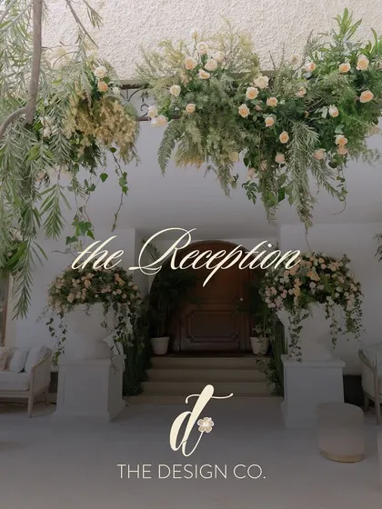 A title card for 'the Reception', set against a backdrop of hanging florals, indicating an elegant and nature-inspired celebration.