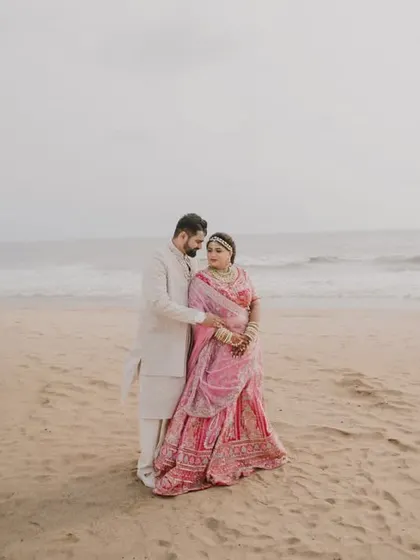 A serene portrait of the couple standing together on the beach, a quiet moment of togetherness.