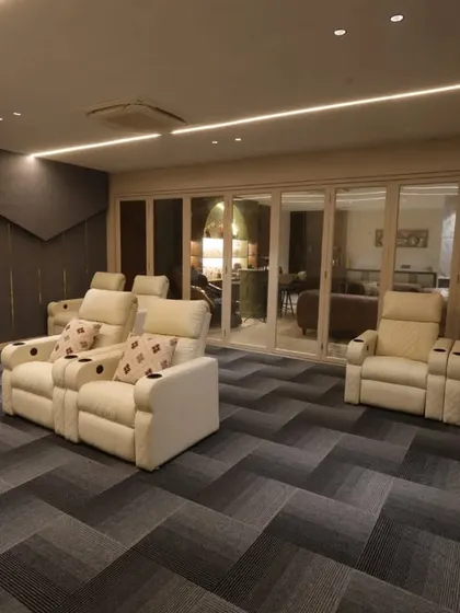 The space is connected to the bar and lounge area through a large glass sliding door, allowing for seamless entertaining.
