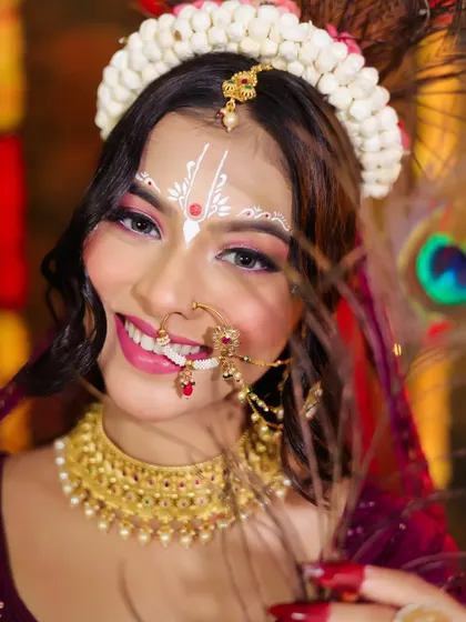A stunning close-up of Radha, showcasing the intricate white 'chandan' art on her forehead and nose.