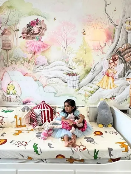 A little girl enjoys her magical new room, complete with a whimsical fairy and enchanted forest mural that turns her bedroom into a storybook.