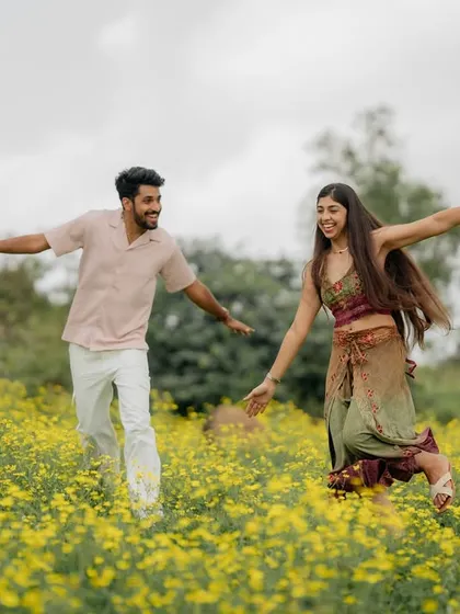 Another joyful moment of the couple running through the field. Their coordinated movements and happy expressions tell a story of partnership.